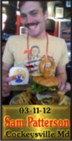 Cup Burger Challenge finisher holding their gold name plaque at Cruisin Café