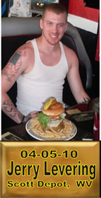 Cup Burger Challenge finisher holding their gold name plaque at Cruisin Café