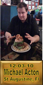 Cup Burger Challenge finisher holding their gold name plaque at Cruisin Café