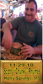 Cup Burger Challenge finisher holding their gold name plaque at Cruisin Café