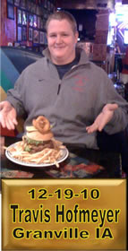 Cup Burger Challenge finisher holding their gold name plaque at Cruisin Café