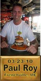 Cup Burger Challenge finisher holding their gold name plaque at Cruisin Café