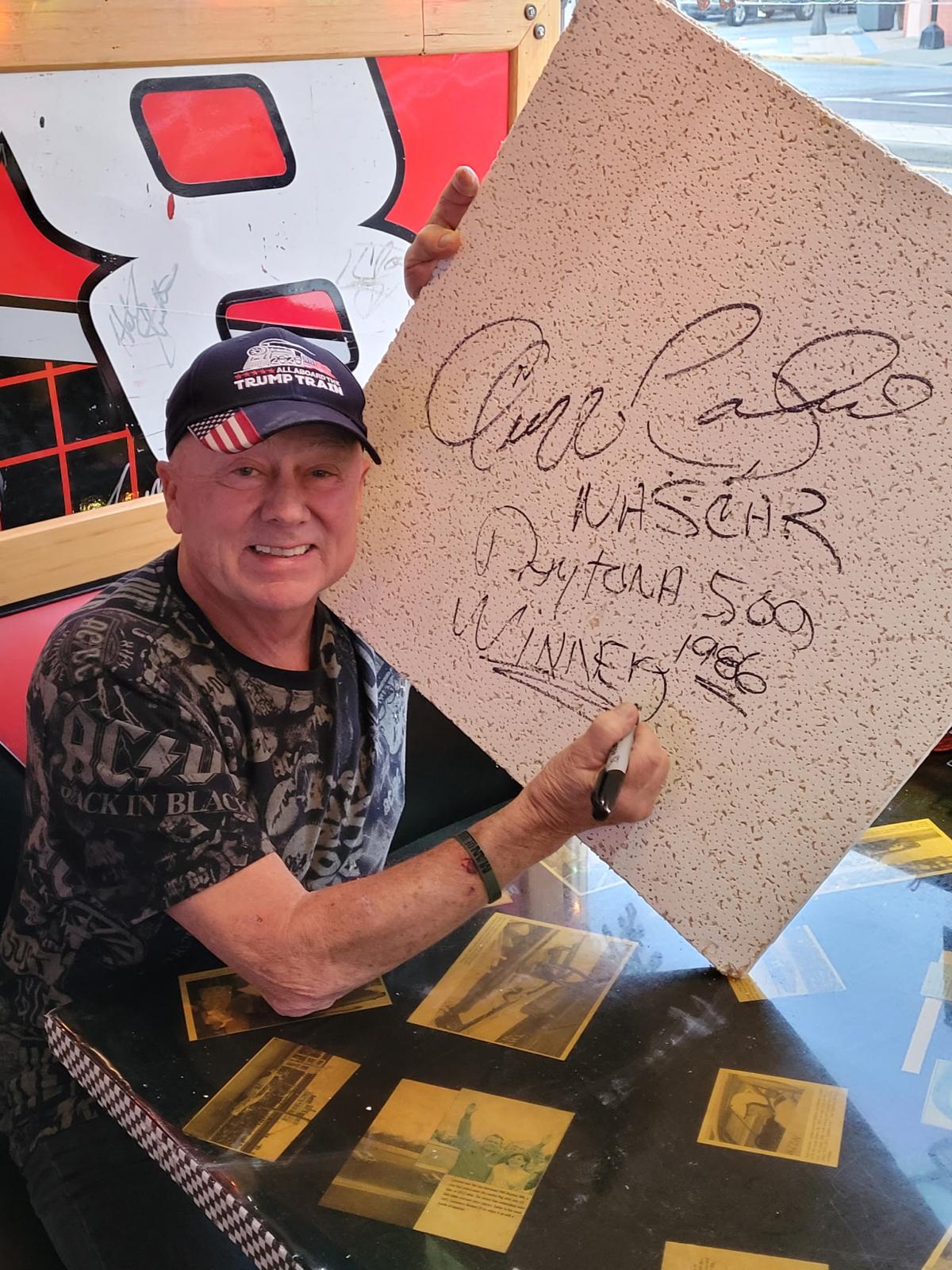 Geoff Bodine signs a ceiling tile — 1986 Daytona 500 winner.