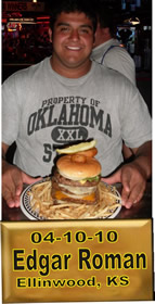 Cup Burger Challenge finisher holding their gold name plaque at Cruisin Café