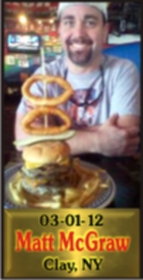 Cup Burger Challenge finisher holding their gold name plaque at Cruisin Café