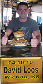 Cup Burger Challenge finisher holding their gold name plaque at Cruisin Café