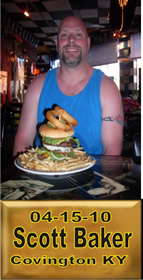 Cup Burger Challenge finisher holding their gold name plaque at Cruisin Café