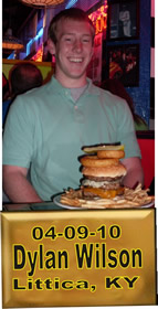 Cup Burger Challenge finisher holding their gold name plaque at Cruisin Café