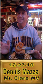 Cup Burger Challenge finisher holding their gold name plaque at Cruisin Café