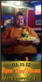 Cup Burger Challenge finisher holding their gold name plaque at Cruisin Café