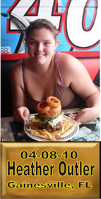 Cup Burger Challenge finisher holding their gold name plaque at Cruisin Café