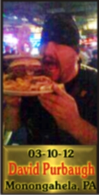 Cup Burger Challenge finisher holding their gold name plaque at Cruisin Café