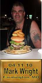 Cup Burger Challenge finisher holding their gold name plaque at Cruisin Café